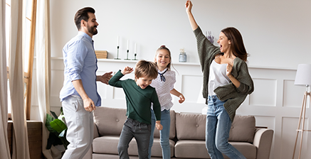 Happy family dancing in living room