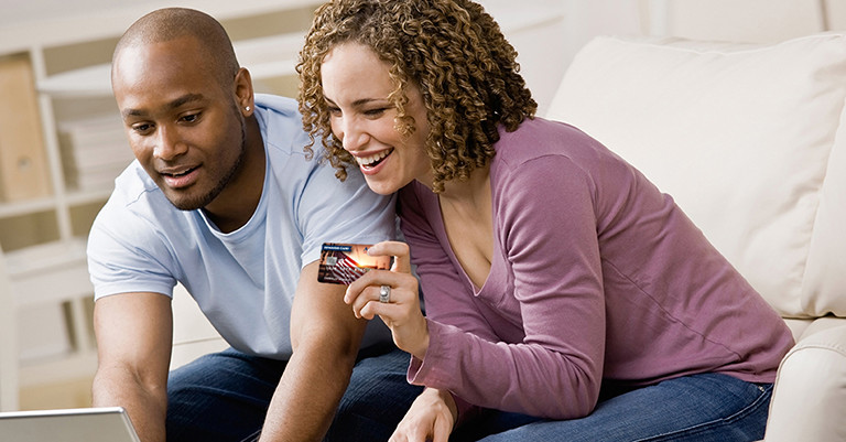 Couple using card at laptop