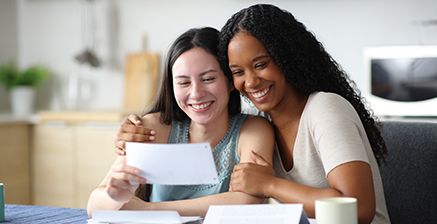 Two women holding a check