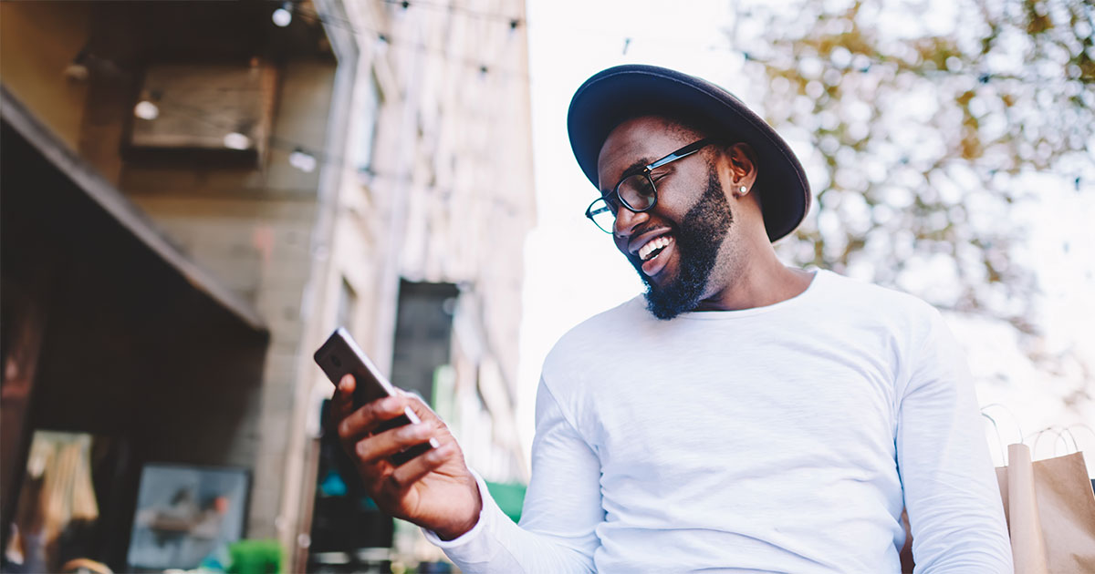 man looking at phone smiling